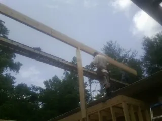 Carpenter setting a ridge beam over a new addition frame — Ice Dam Removal by Roofing Brothers in Nehawka