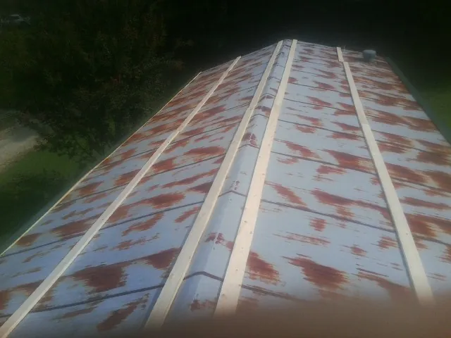 Rusted metal roof panels with new wood purlins before replacement — Storm Damage Roof Repair in Nehawka by Roofing Brothers