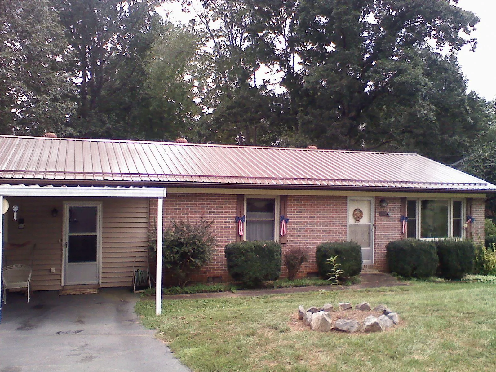 Bronze metal roof and carport on a brick ranch home — Roof Repair work by our crew in Nehawka